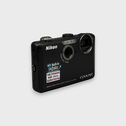 Angled front view of a black Nikon Coolpix S1100pj showing its camera lens and separate projector lens