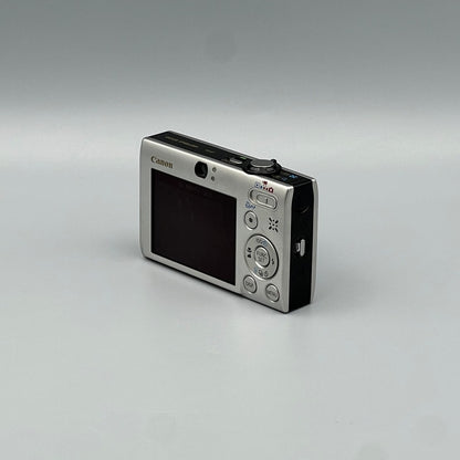 Angled rear view of a silver Canon PowerShot SD770 IS showing its screen, control buttons and black side panel