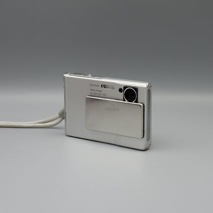 Front and side view of a silver Sony Cyber-shot DSC-T7 showing the exposed lens