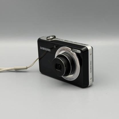Black Samsung PL100 viewed from the opposite front corner with its extended lens and silver side panel visible