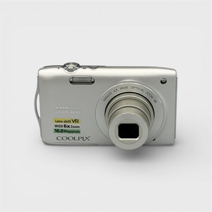 Front view of a silver Nikon Coolpix S3300 digital camera with its lens extended