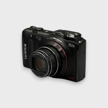 Black Fujifilm FinePix F550EXR viewed from a front angle showing its extended zoom lens, raised flash and side panel.