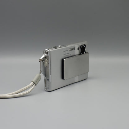 Angled front view of a silver Sony Cyber-shot DSC-T7 showing the exposed lens and top controls