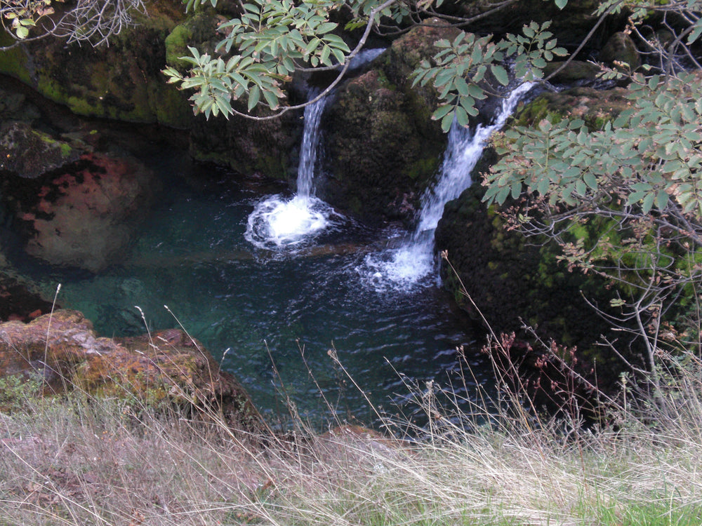 Twin falls into a turquoise pool at Radac