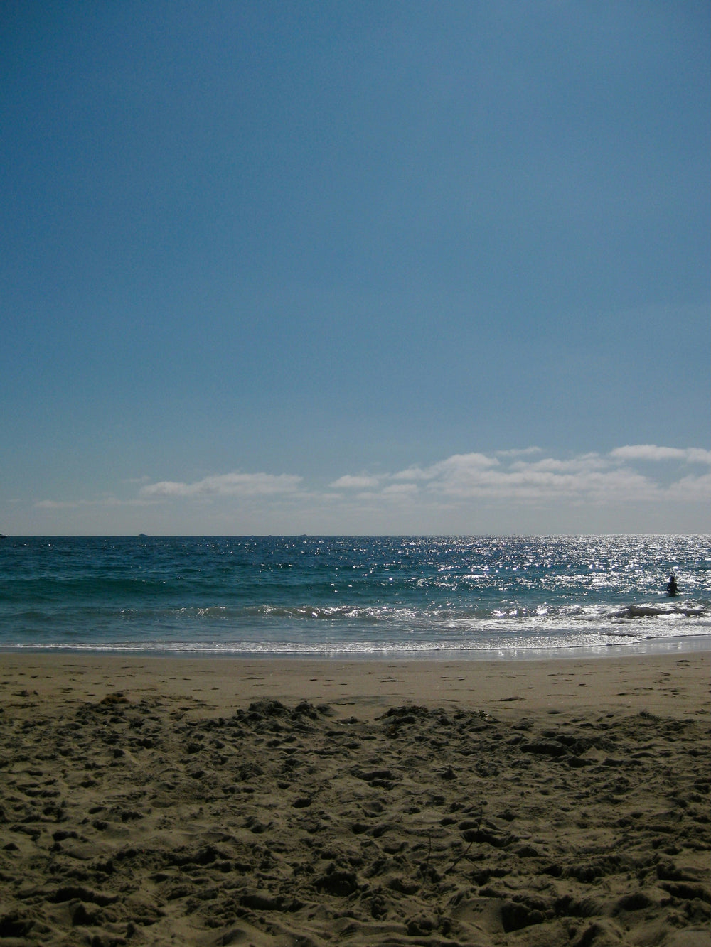Blue sky above sparkling sea and sandy beach