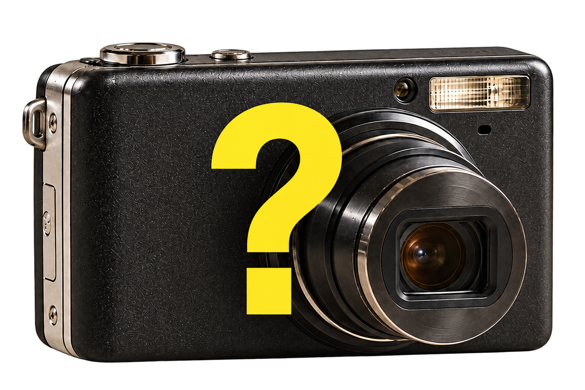 Representative black mystery digital camera with a yellow question mark. Camera model, color and accessories vary.